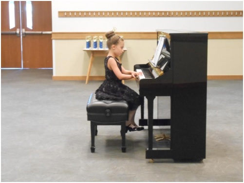 Young girl playing piano at recital
